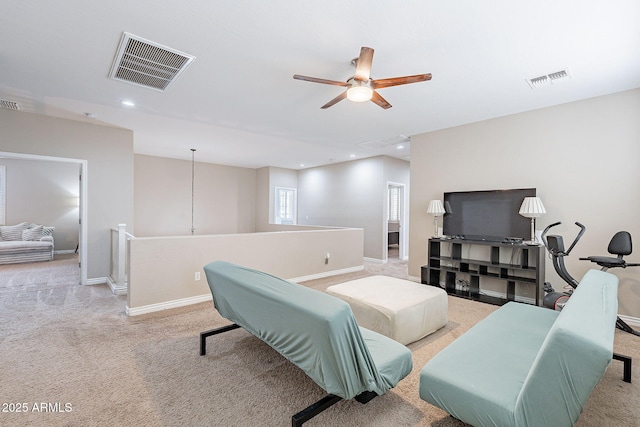 living room featuring visible vents, light carpet, and baseboards