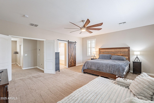 bedroom featuring a barn door, baseboards, visible vents, and light carpet