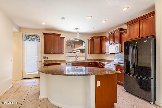 kitchen featuring light tile patterned floors, a center island, white appliances, dark stone countertops, and sink