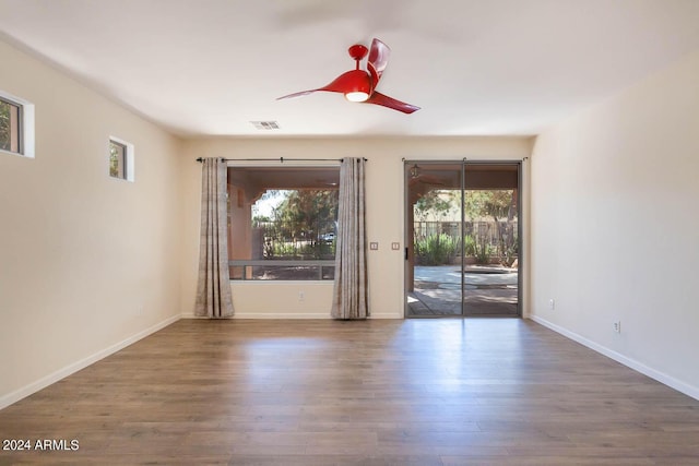 unfurnished room with ceiling fan, a wealth of natural light, and dark hardwood / wood-style floors