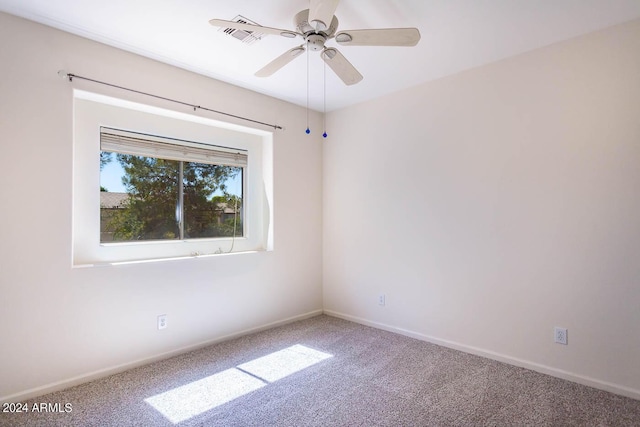 unfurnished room with ceiling fan and carpet