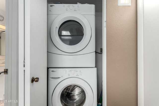 washroom featuring stacked washer / drying machine