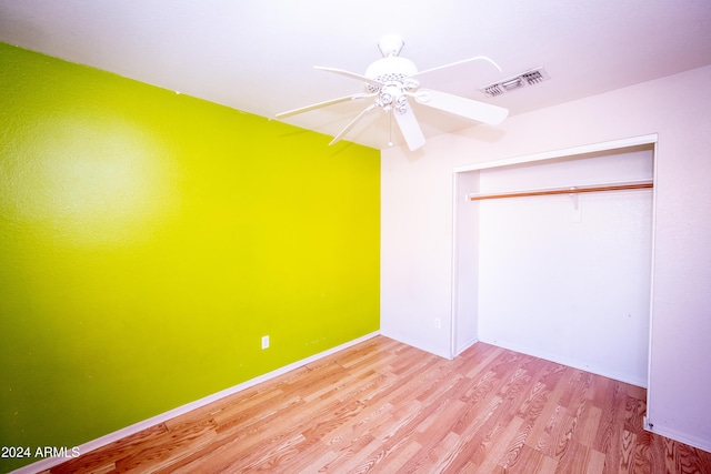 unfurnished bedroom featuring ceiling fan, a closet, and light hardwood / wood-style flooring