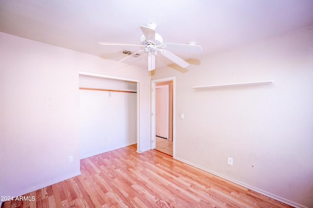 unfurnished bedroom with ceiling fan, a closet, and light wood-type flooring