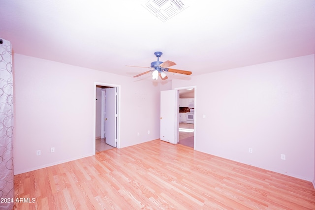 empty room featuring ceiling fan and light hardwood / wood-style flooring