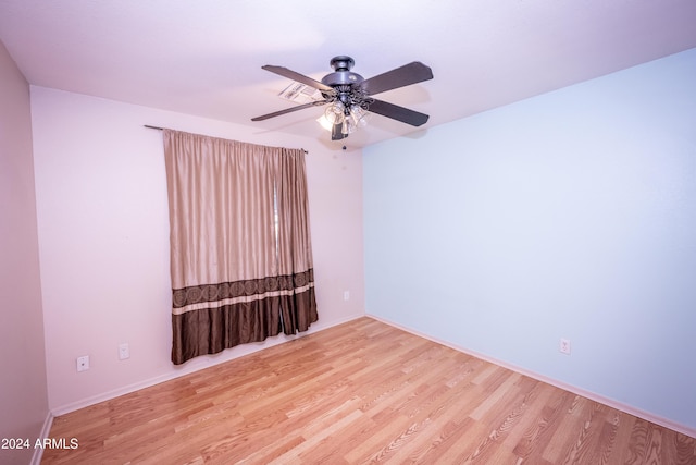 empty room with ceiling fan and light hardwood / wood-style flooring