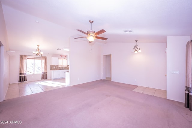 unfurnished living room with light carpet, ceiling fan with notable chandelier, and vaulted ceiling