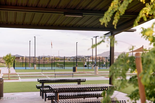 view of community with a mountain view and tennis court