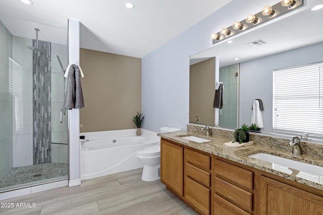 bathroom featuring a bath, visible vents, a stall shower, and a sink