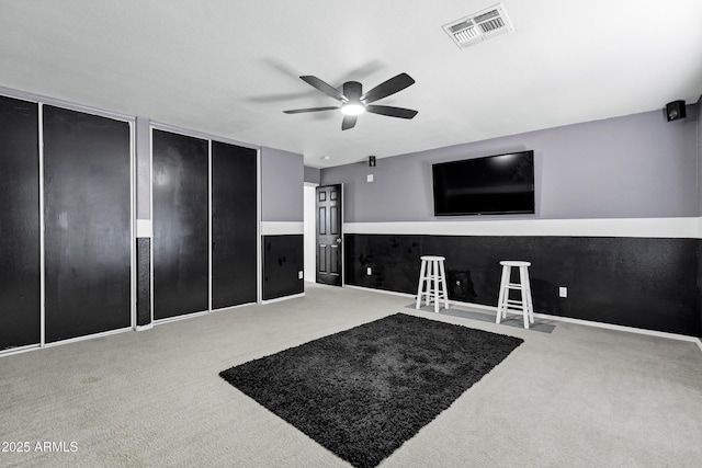 interior space with visible vents, carpet floors, and ceiling fan