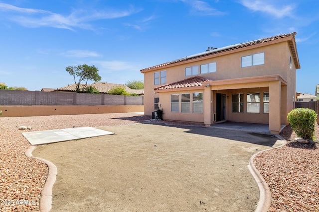 back of property featuring a fenced backyard, stucco siding, a tiled roof, and a patio