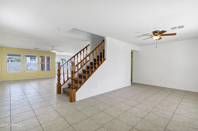 interior space featuring visible vents, a ceiling fan, light tile patterned flooring, and stairs