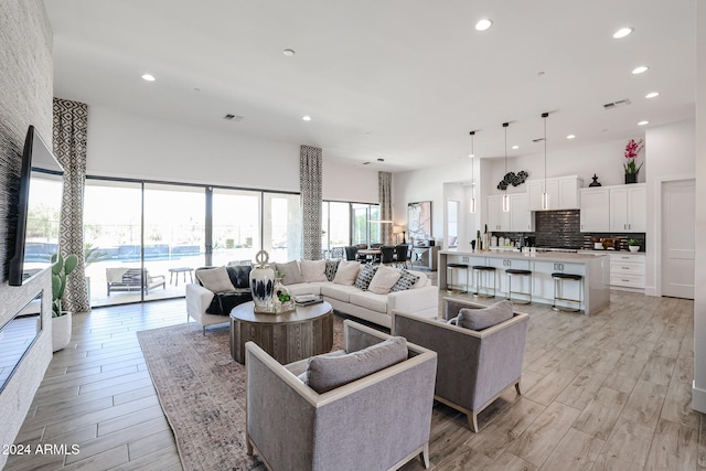 living room featuring a towering ceiling and light hardwood / wood-style floors