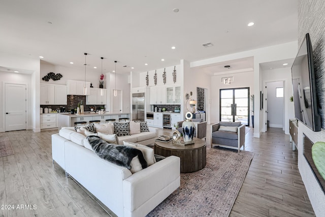 living room featuring beverage cooler and light hardwood / wood-style flooring