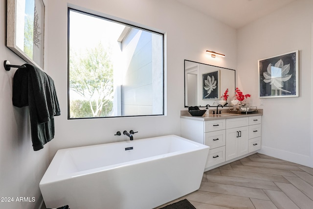 bathroom featuring vanity, a tub, and parquet floors