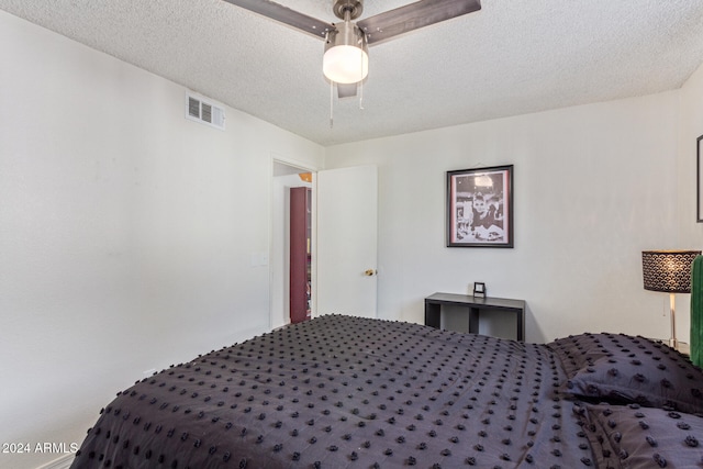 bedroom with ceiling fan and a textured ceiling