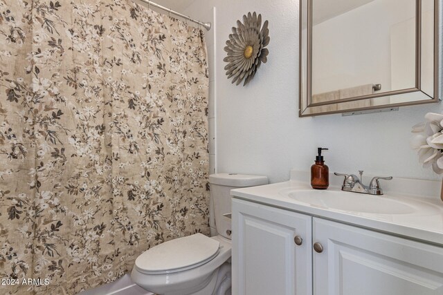 bathroom with a shower with curtain, vanity, and toilet