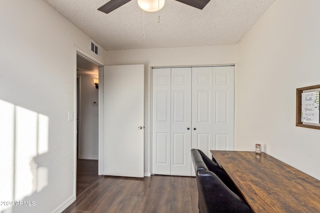 unfurnished office with ceiling fan, dark hardwood / wood-style flooring, and a textured ceiling