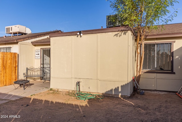 view of home's exterior with a fire pit, a patio area, and central air condition unit