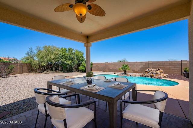 view of patio / terrace with a fenced in pool, outdoor dining area, a fenced backyard, and ceiling fan