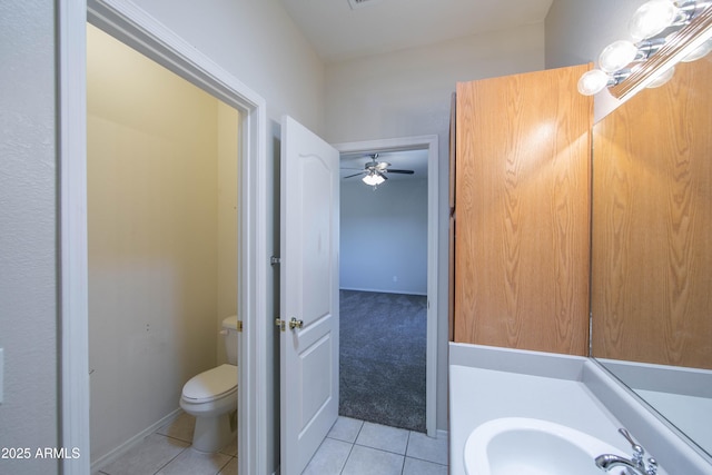 bathroom with baseboards, a sink, toilet, and tile patterned floors