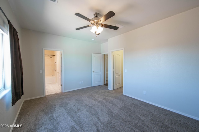 unfurnished bedroom with ceiling fan, connected bathroom, baseboards, and carpet flooring