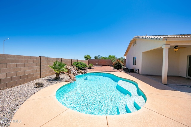 view of swimming pool featuring a patio area, a fenced backyard, a fenced in pool, and a ceiling fan