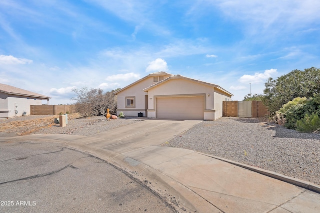 single story home featuring concrete driveway, fence, a gate, and stucco siding