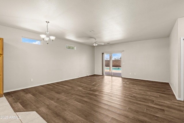 unfurnished room featuring visible vents, baseboards, dark wood-style flooring, and ceiling fan with notable chandelier