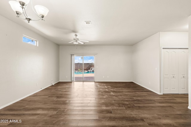 empty room with visible vents, dark wood finished floors, baseboards, and ceiling fan with notable chandelier