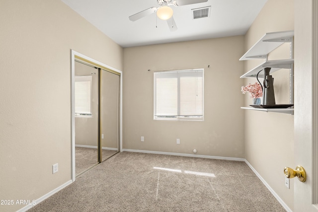 unfurnished bedroom with carpet floors, baseboards, visible vents, and a closet