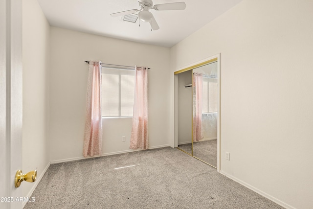 unfurnished bedroom with carpet, a closet, baseboards, and a ceiling fan