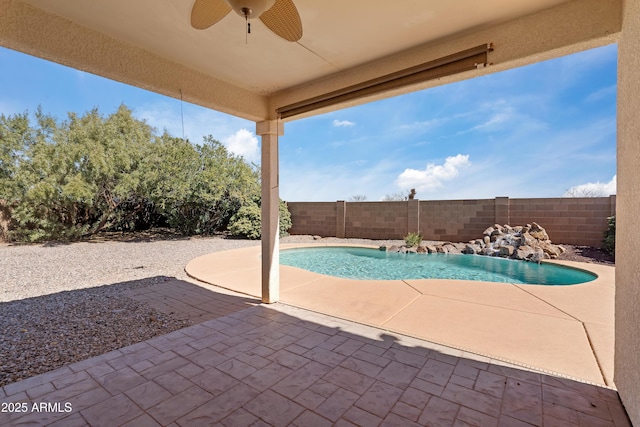 view of pool featuring a patio area, a fenced backyard, and a ceiling fan