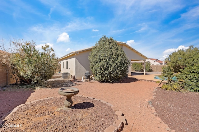 back of house featuring a patio, central AC unit, fence, and stucco siding