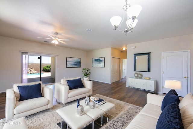 living area featuring ceiling fan with notable chandelier, wood finished floors, visible vents, and baseboards