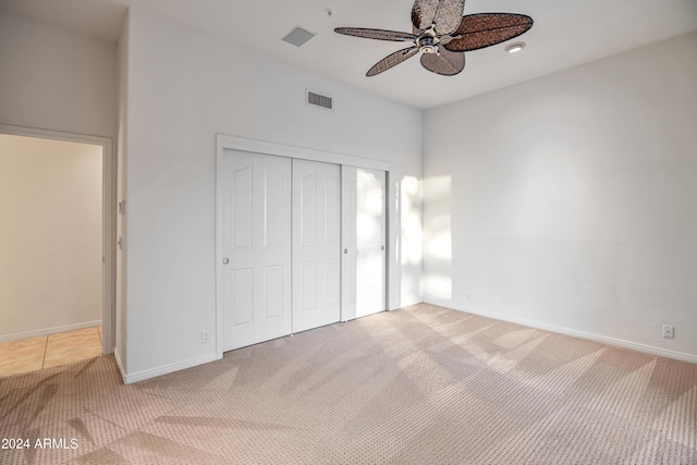 unfurnished bedroom with ceiling fan, a closet, and carpet floors