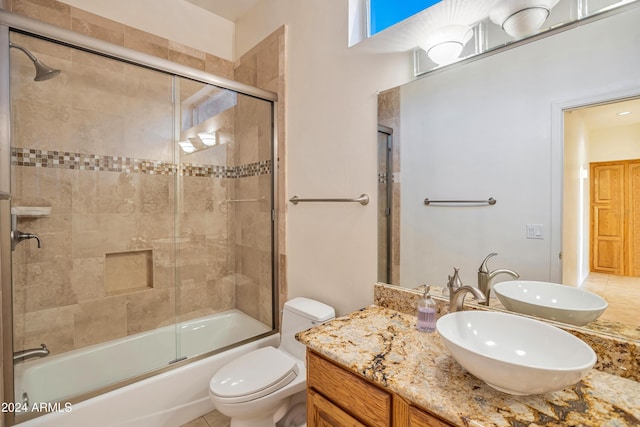 full bathroom featuring toilet, combined bath / shower with glass door, and vanity