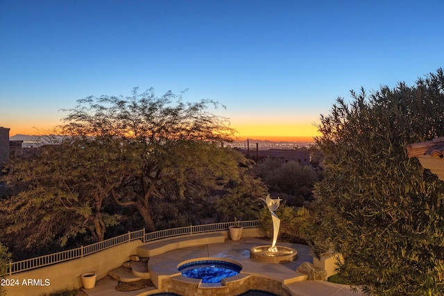 patio terrace at dusk with an in ground hot tub