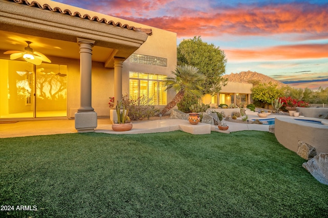 exterior space featuring a lawn and ceiling fan