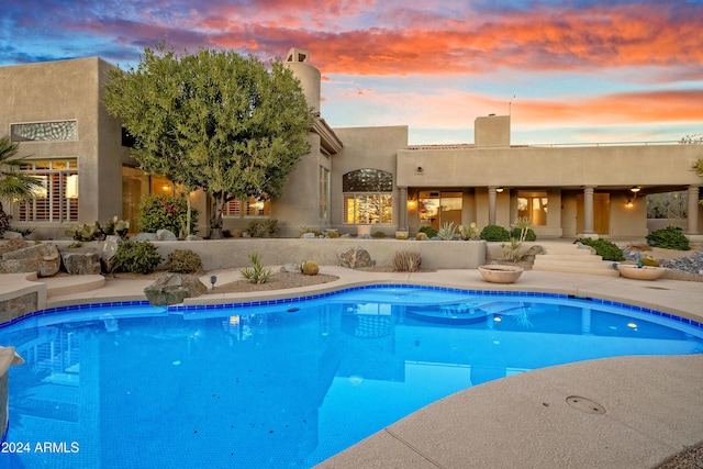 view of pool at dusk