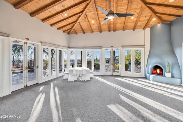 unfurnished sunroom with lofted ceiling with beams, ceiling fan, wood ceiling, and french doors