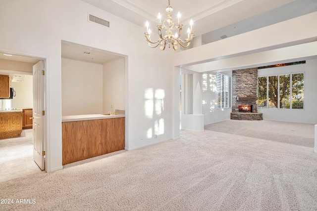 unfurnished living room with light carpet, sink, and an inviting chandelier