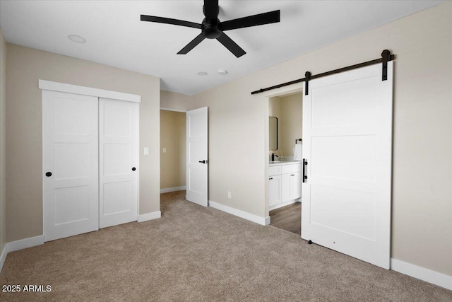2559 E Broadway Rd, Phoenix, AZ 85040 - unfurnished bedroom with carpet flooring, a barn door, a closet, ensuite bath, and ceiling fan