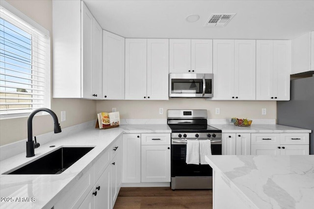 2559 E Broadway Rd, Phoenix, AZ 85040 - kitchen featuring appliances with stainless steel finishes, light stone counters, and white cabinets
