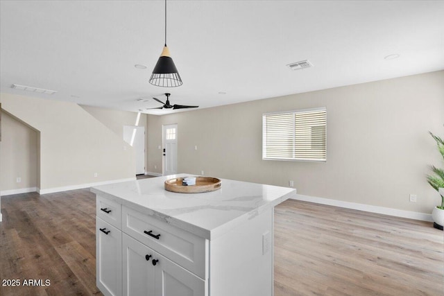 2559 E Broadway Rd, Phoenix, AZ 85040 - kitchen featuring open floor plan, light wood-style flooring, a ceiling fan, and white cabinets