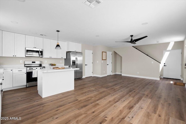 2559 E Broadway Rd, Phoenix, AZ 85040 - kitchen featuring stainless steel appliances, open floor plan, a kitchen island, light countertops, and white cabinets