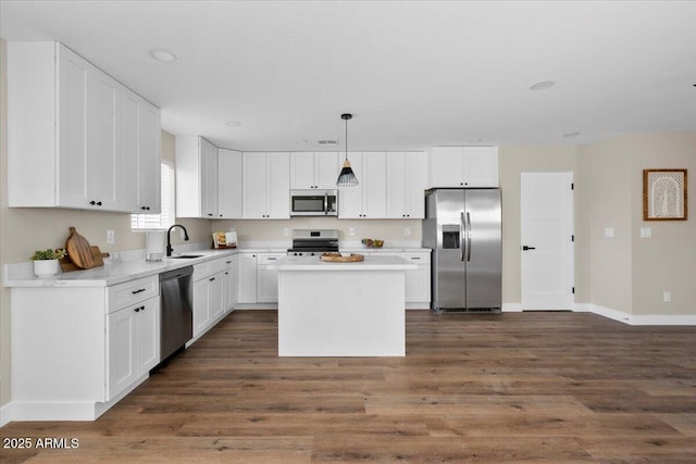 2559 E Broadway Rd, Phoenix, AZ 85040 - kitchen featuring appliances with stainless steel finishes, dark wood-style floors, white cabinets, light countertops, and a kitchen island