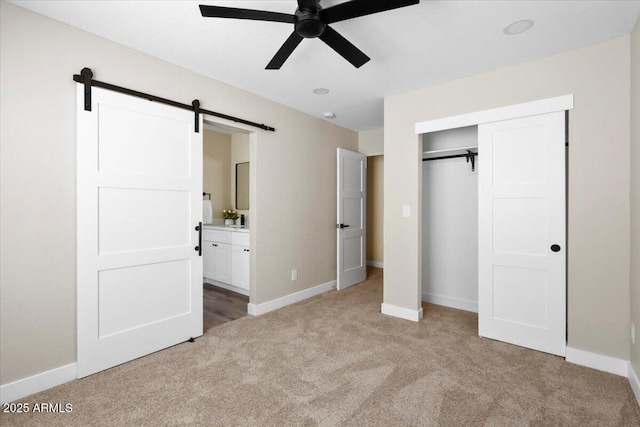 2559 E Broadway Rd, Phoenix, AZ 85040 - unfurnished bedroom with light carpet, a barn door, a closet, connected bathroom, and a ceiling fan