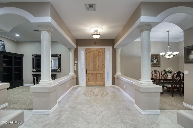 foyer entrance featuring crown molding and ornate columns