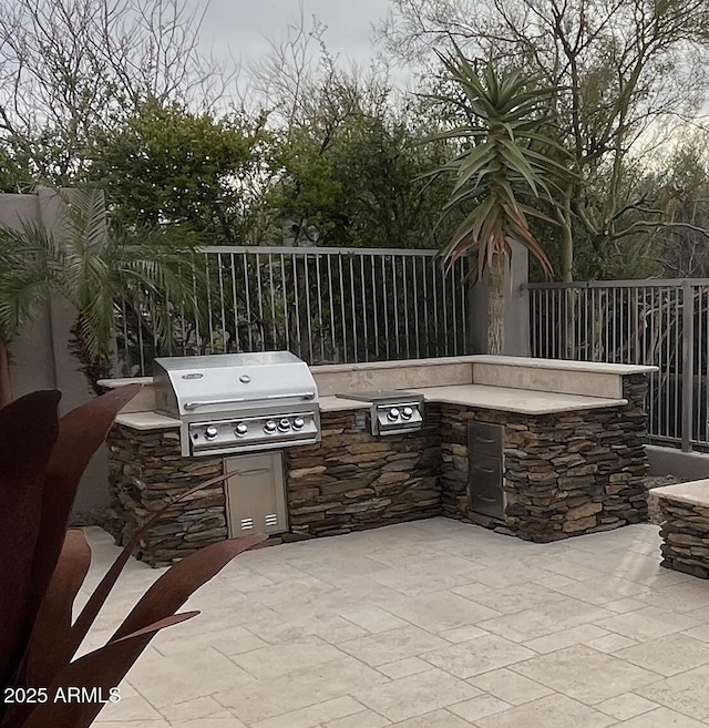 view of patio with grilling area, fence, and area for grilling